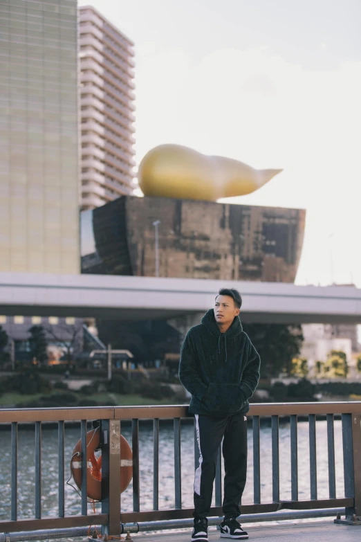 a man stands by the edge of a bridge