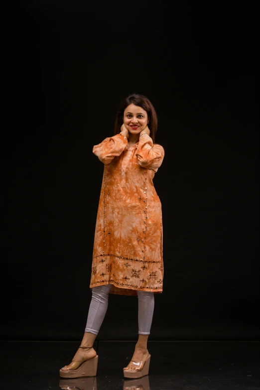 woman standing in front of a black backdrop, smiling for a po