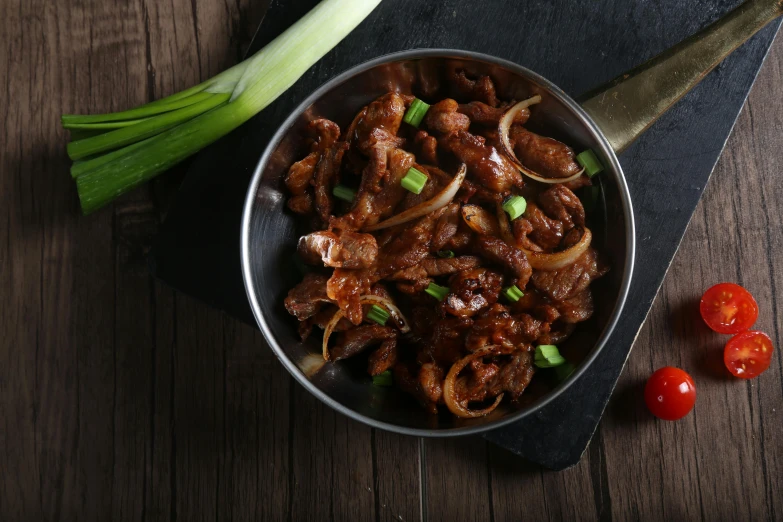 food in a bowl next to a bunch of onions and celery