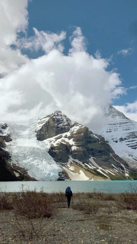 person on a field near snow covered mountains