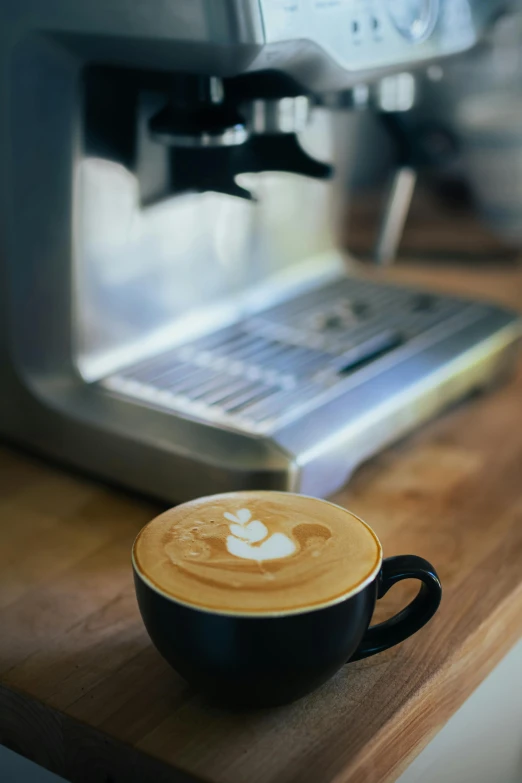 a cup of coffee sitting next to an espresso maker