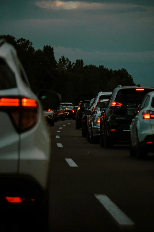 a street full of traffic at dusk with the lights on