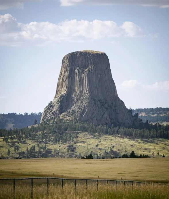 a large, tall rock in the middle of the field