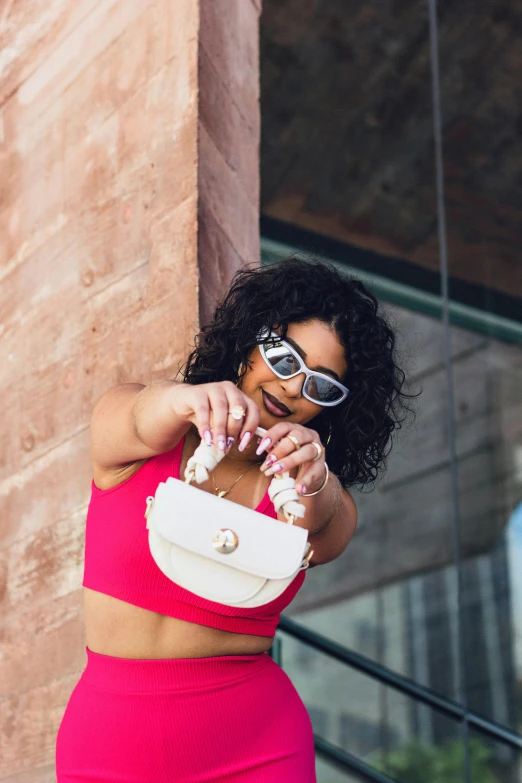 a woman in pink carrying a white purse