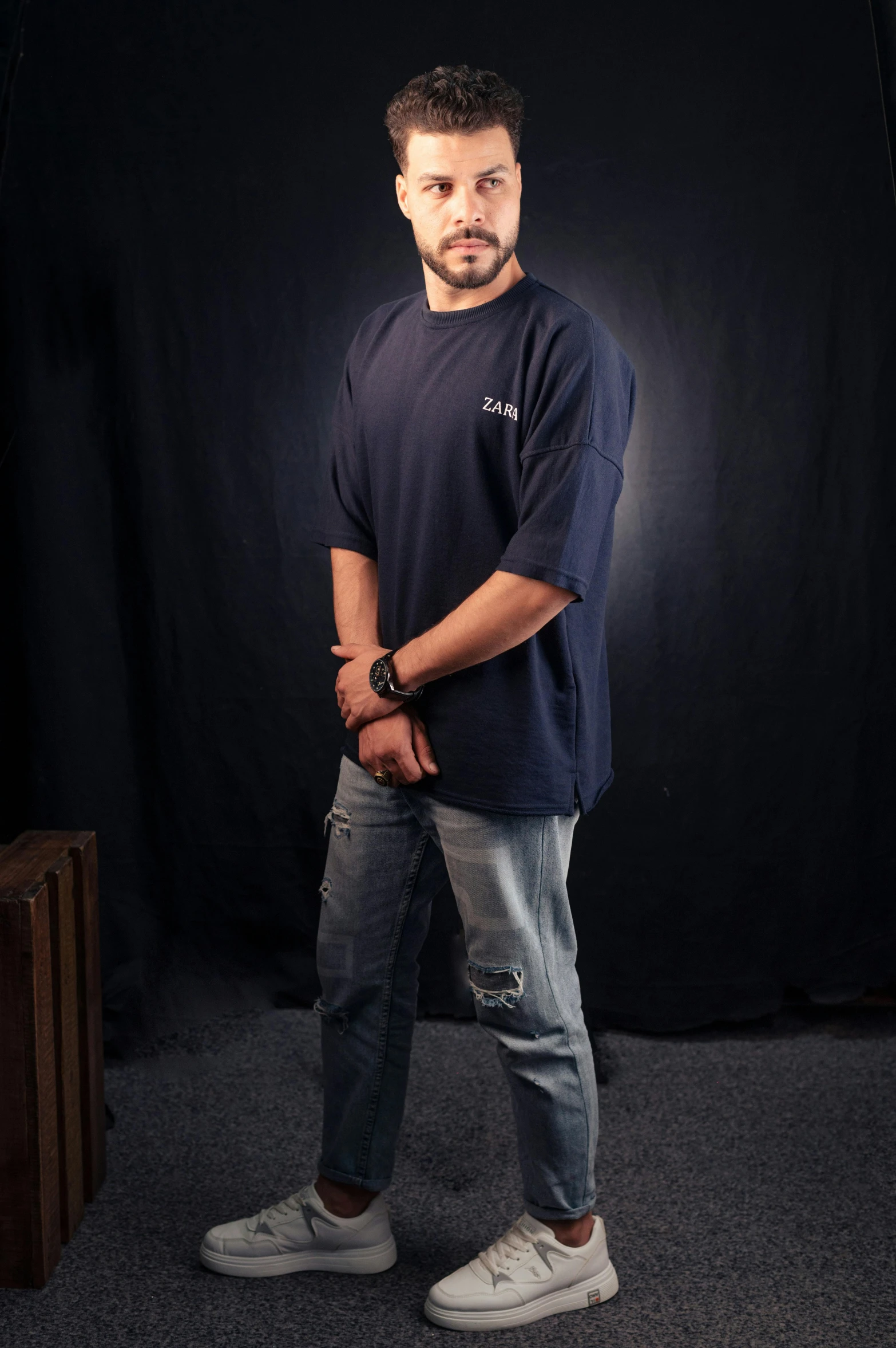 a man standing in a room with black backdrop