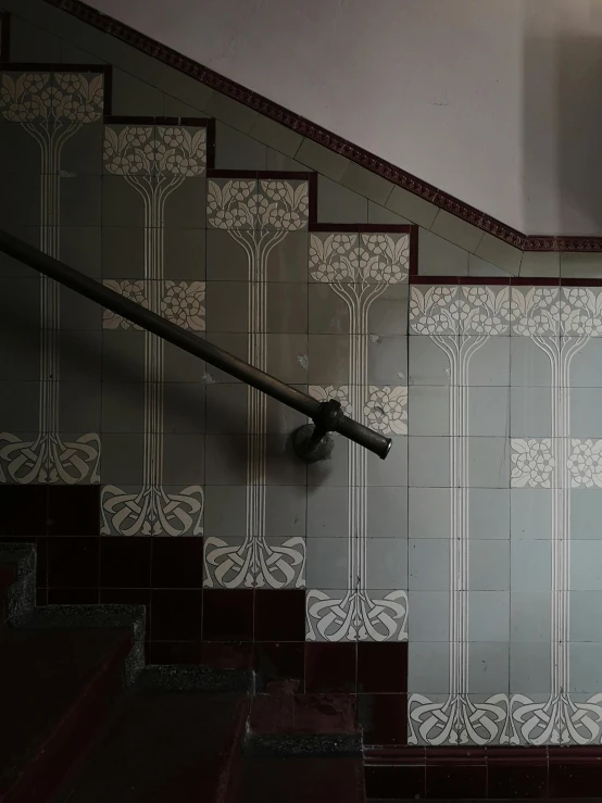 the stairwell features gray and white tiles and red stairs