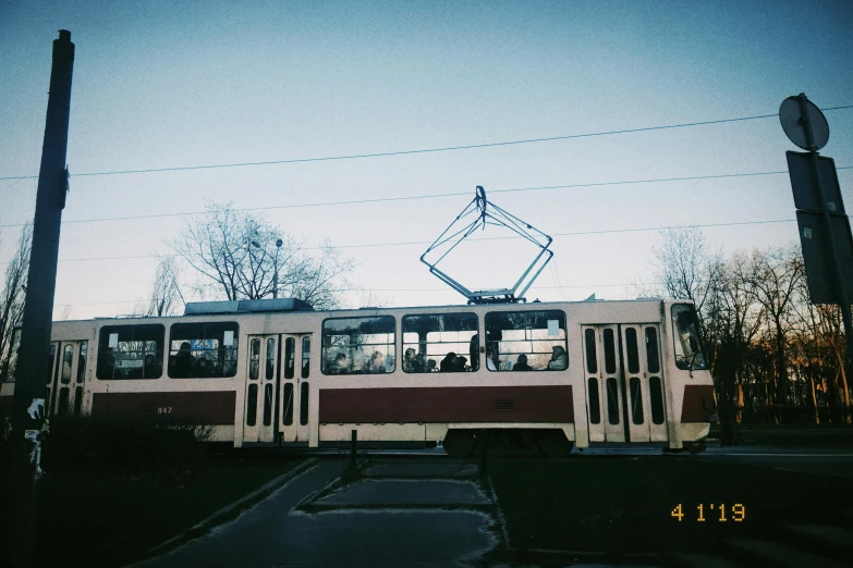 a passenger bus traveling on the tracks at dusk