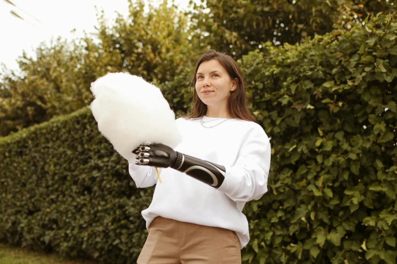 a woman is holding a mop and some cotton floss