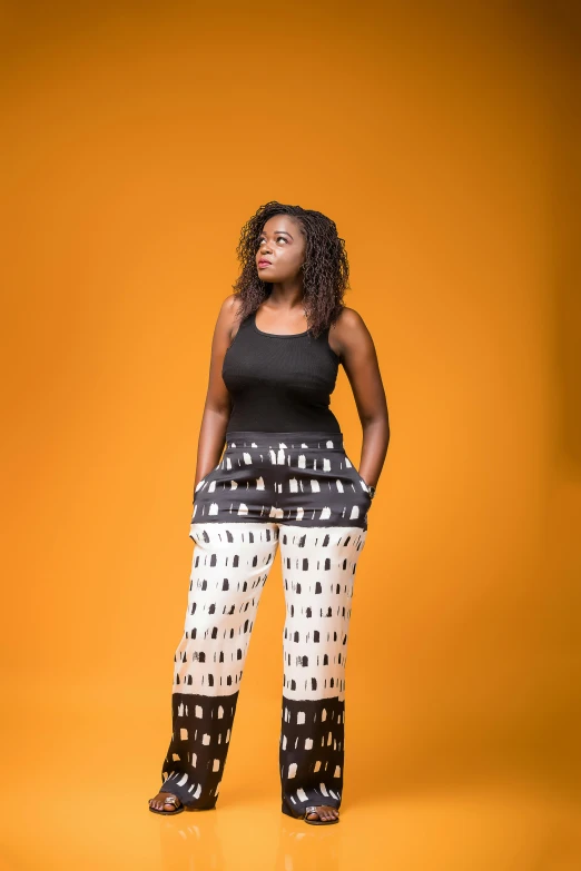 a woman standing in front of an orange background