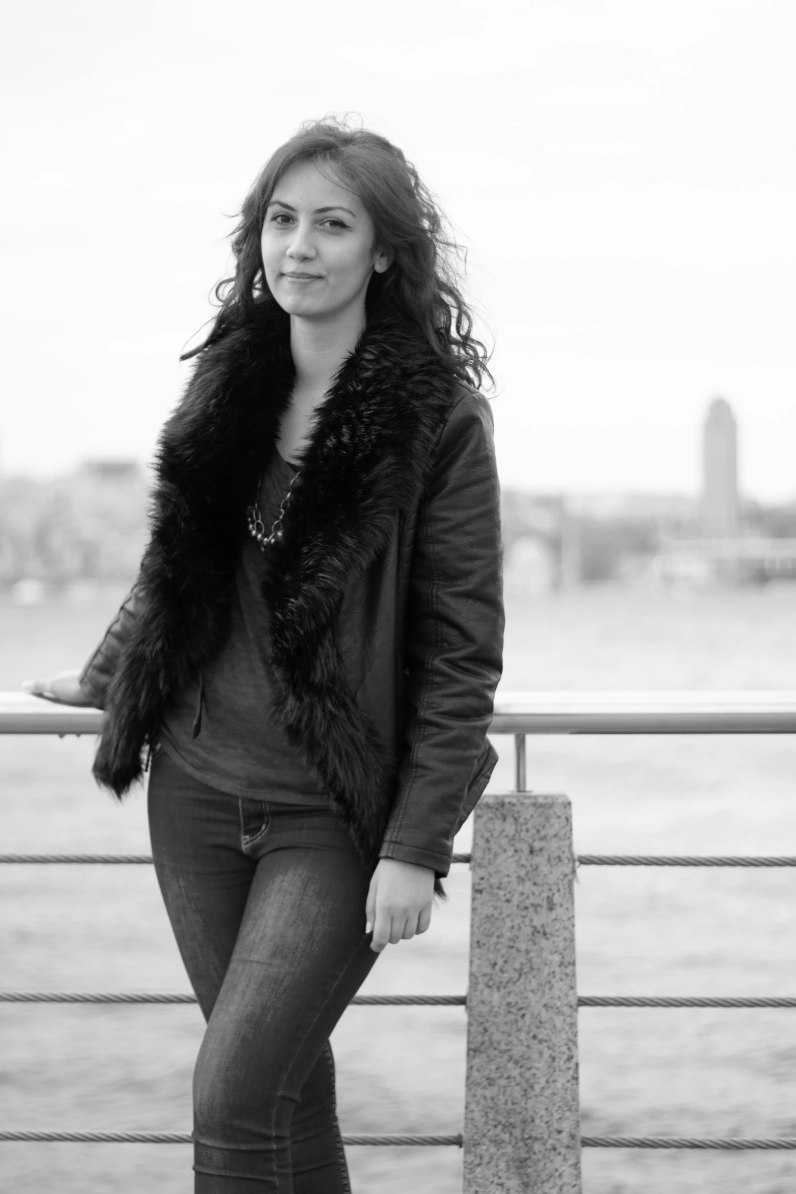 the woman is posing for a pograph by the water