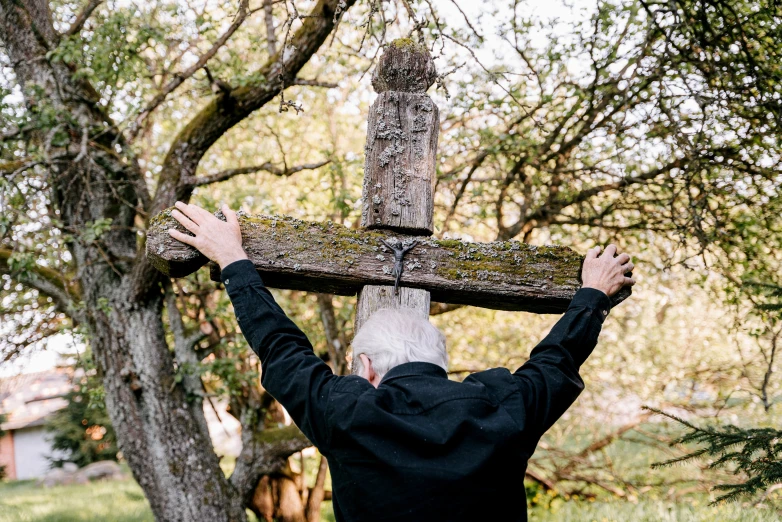 a man is carrying an old wooden cross