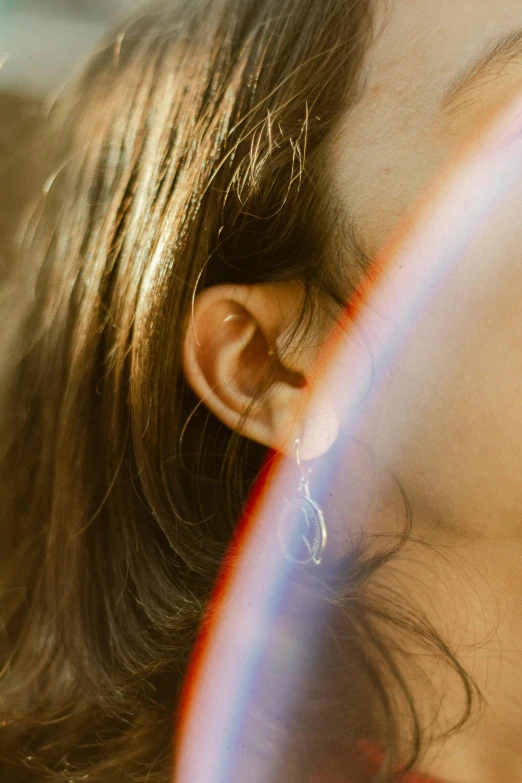 the woman is looking at the sun with her ear piercing