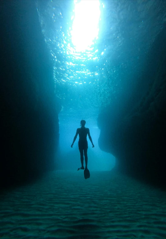 a person with a ski board walking through a cave