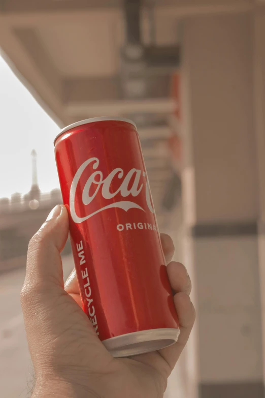 a hand holds a cup full of coke