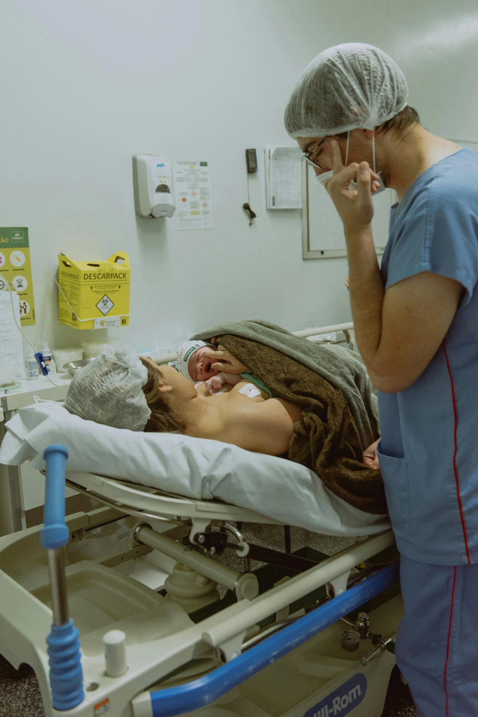 two doctors in scrubs talking on a phone next to a bed