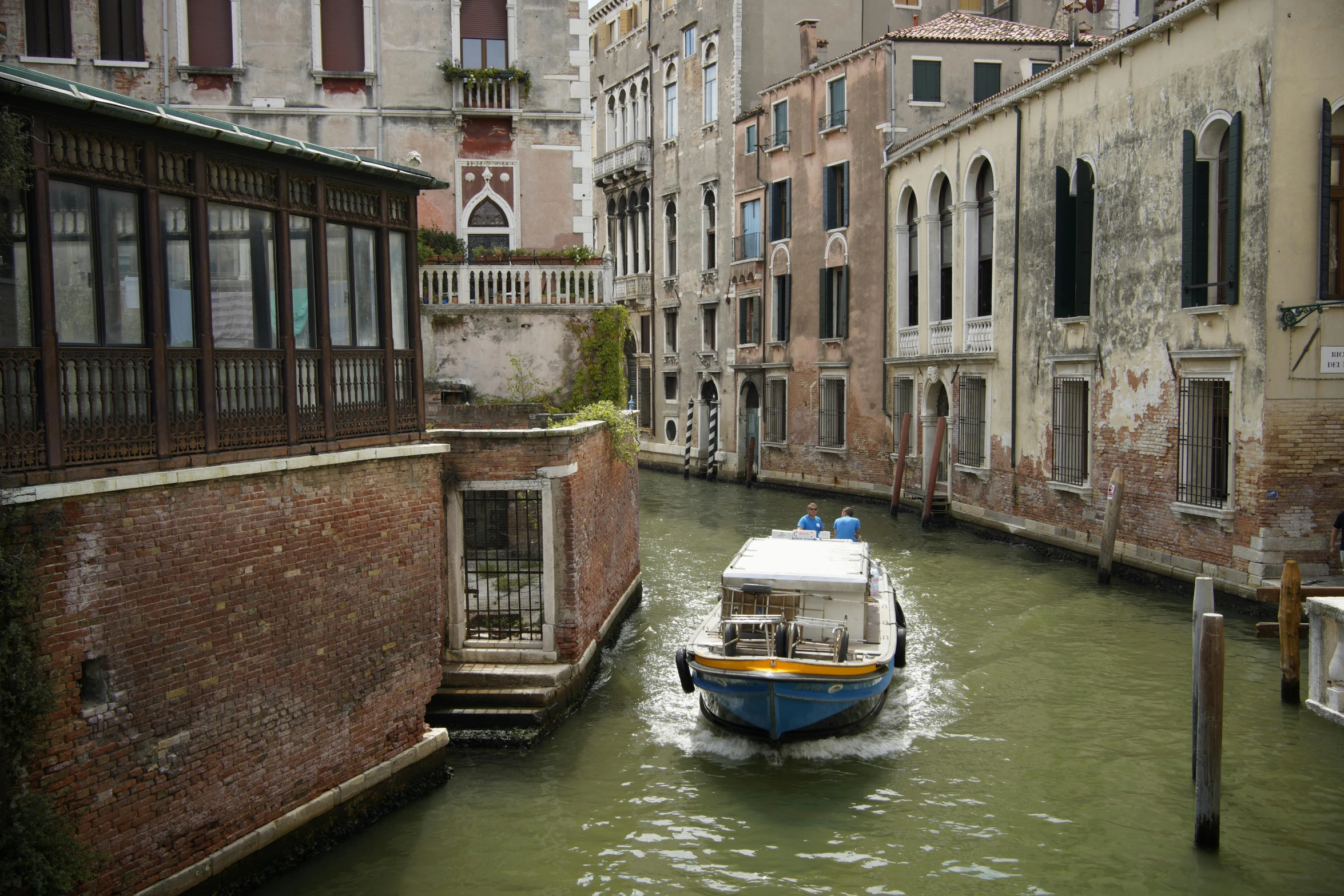 a boat is going down the river in a narrow alleyway