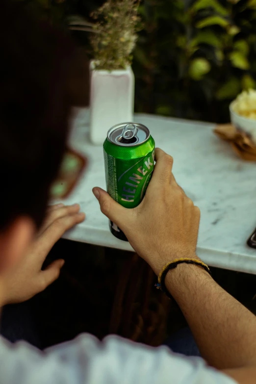 a man sitting at a table with a can of soda