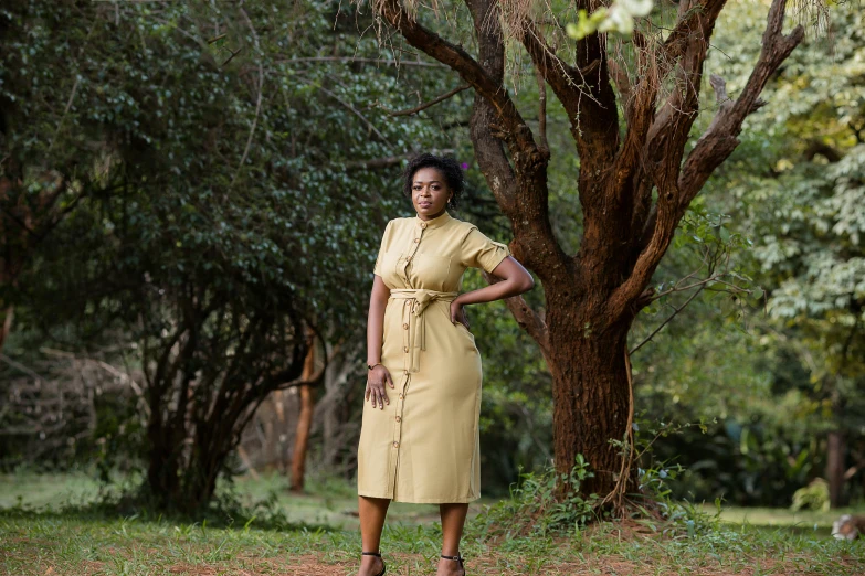 a woman is standing next to trees on the side walk