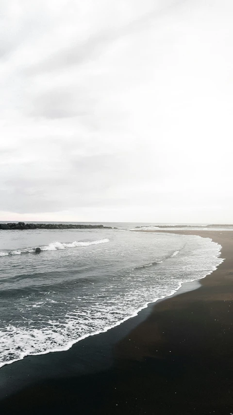 the surfer rides a board on a wet sandy beach