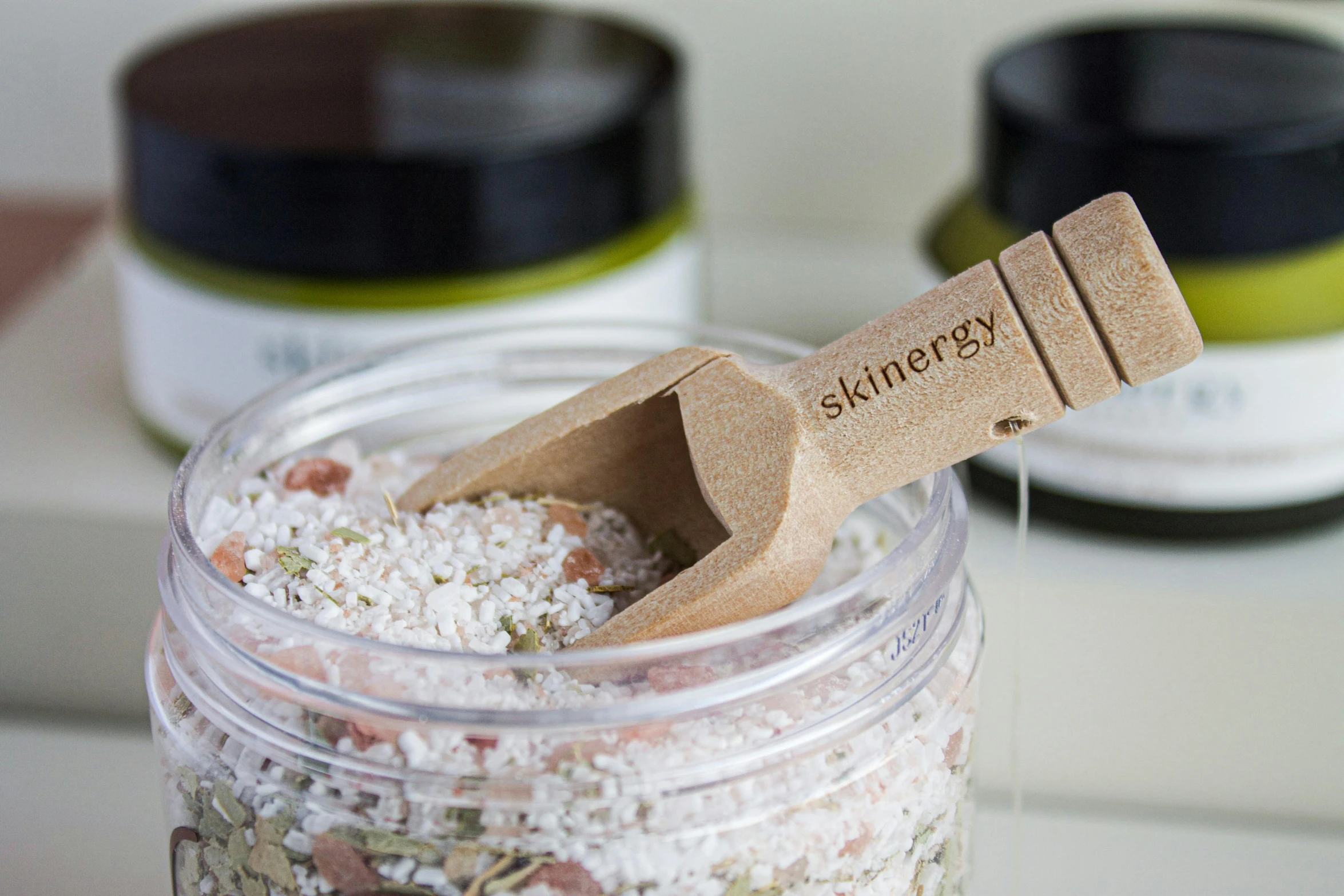 a wooden spoon in a jar of white bath soak