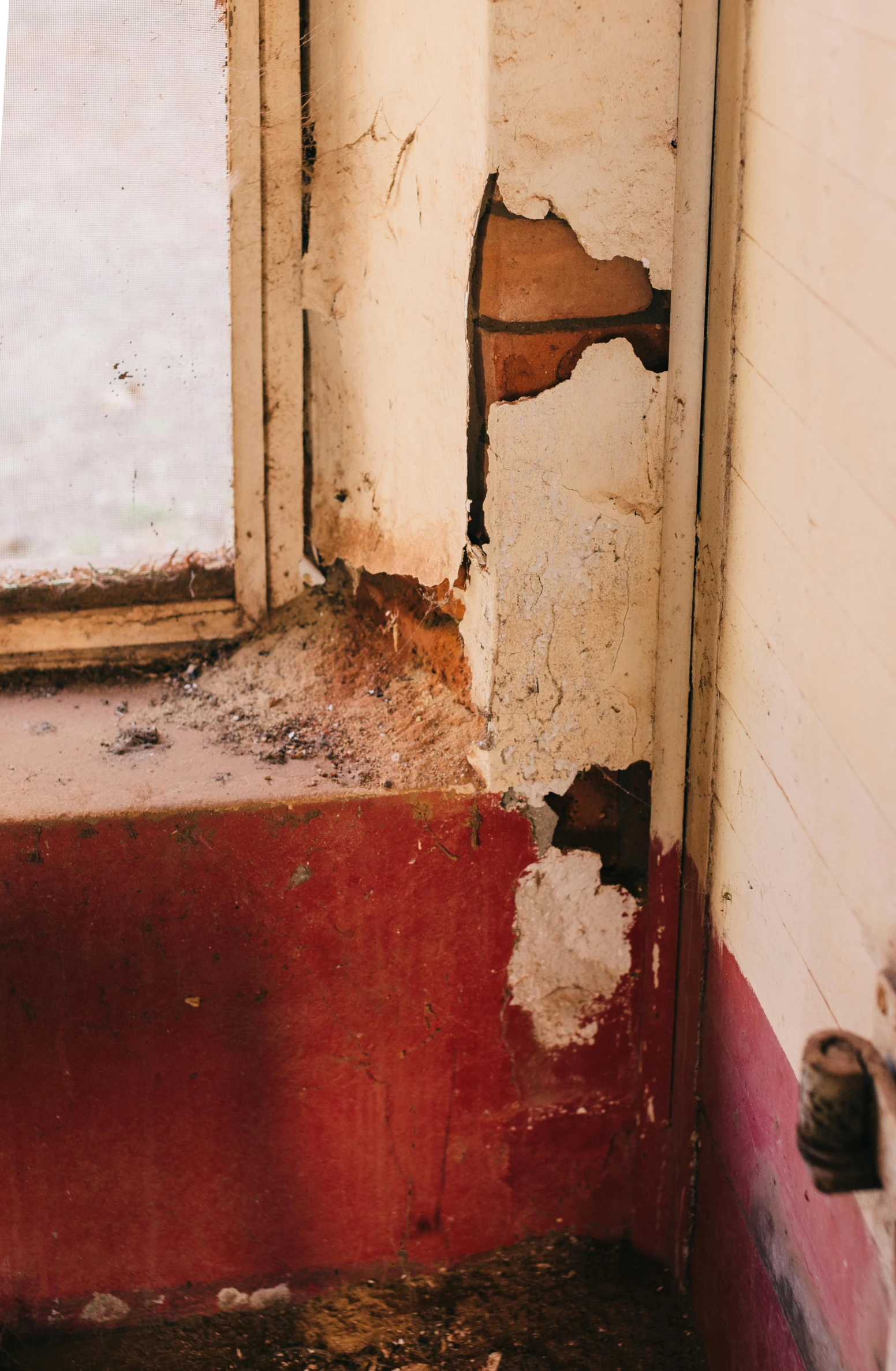 the side of a bathroom with peeling paint