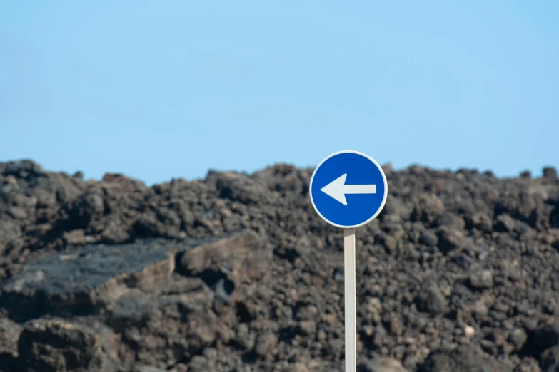 a blue sign with an arrow on top of it