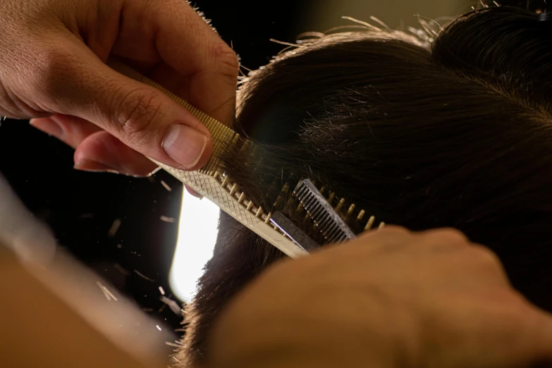 a woman getting her hair brushed with a comb