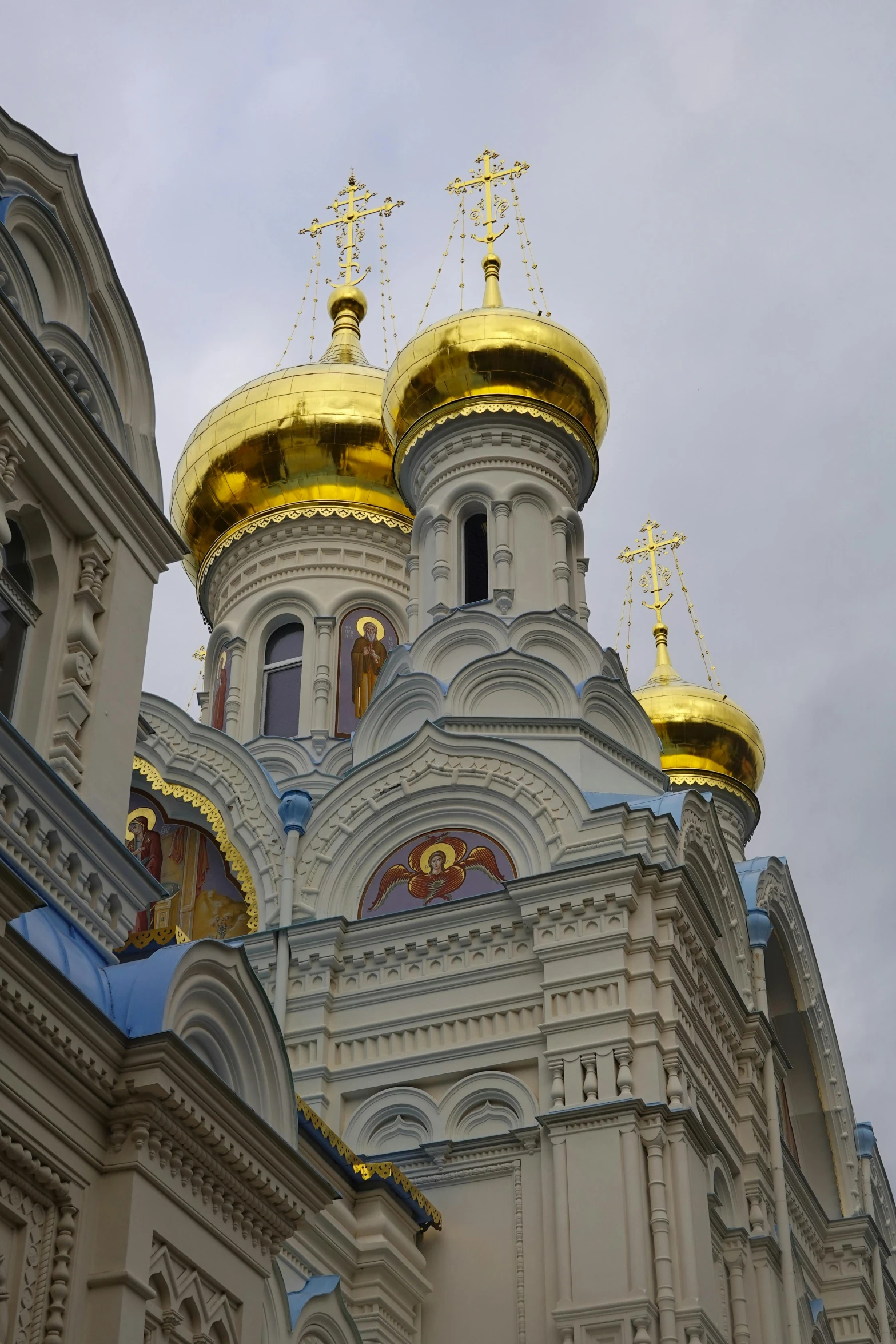 large white and yellow building with gold domes