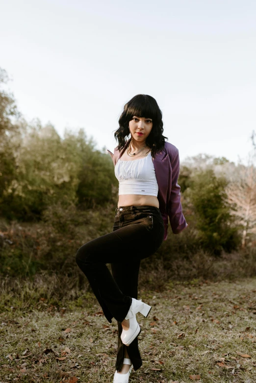 a woman poses with her arm on her knee