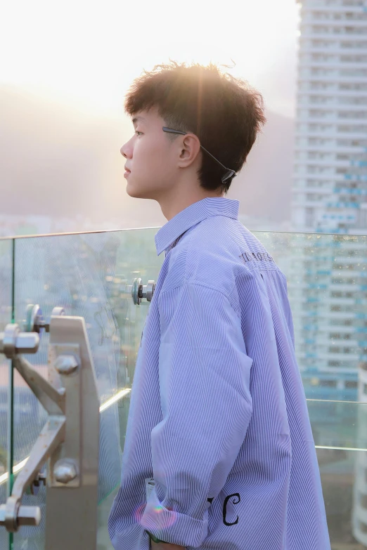 a boy with short hair standing at an outdoor platform