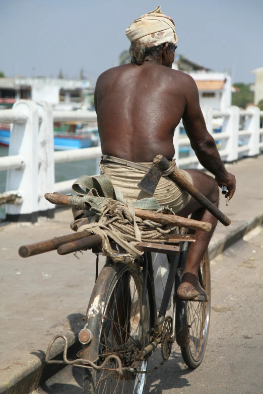 a man is sitting on his bicycle filled with wood