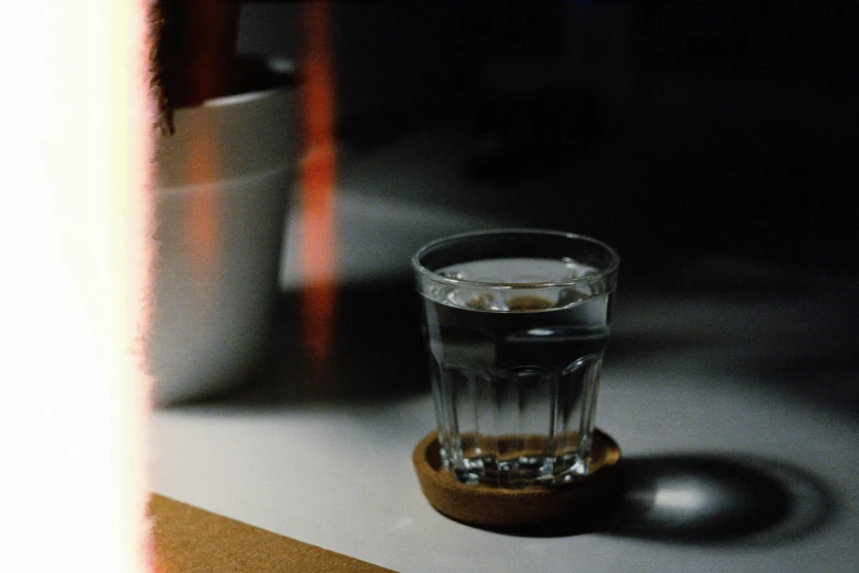 an empty glass sits on a table in the dark