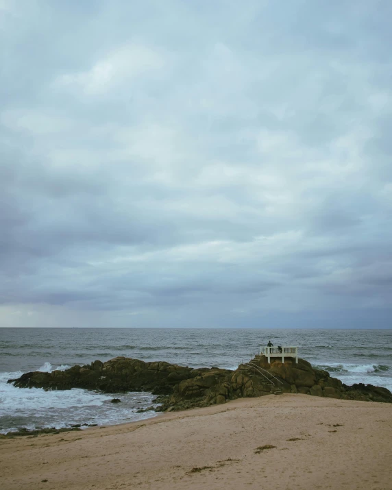 a bench and a small dock on a rocky shoreline