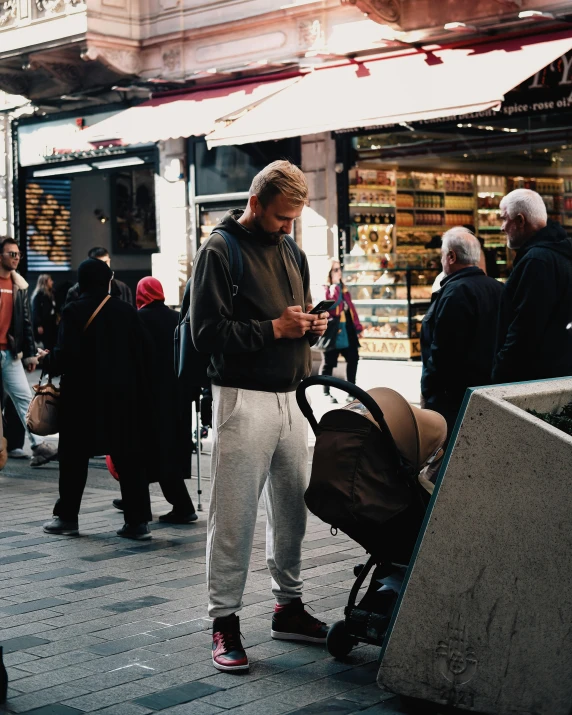 a man standing on the street looking at his cellphone