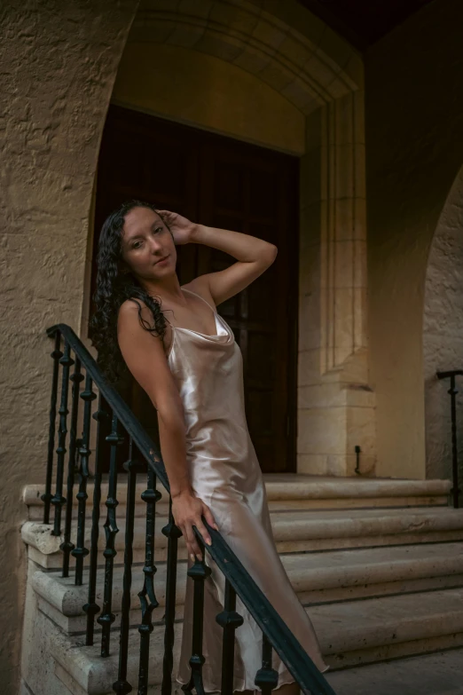 an african american woman in a gown standing on steps