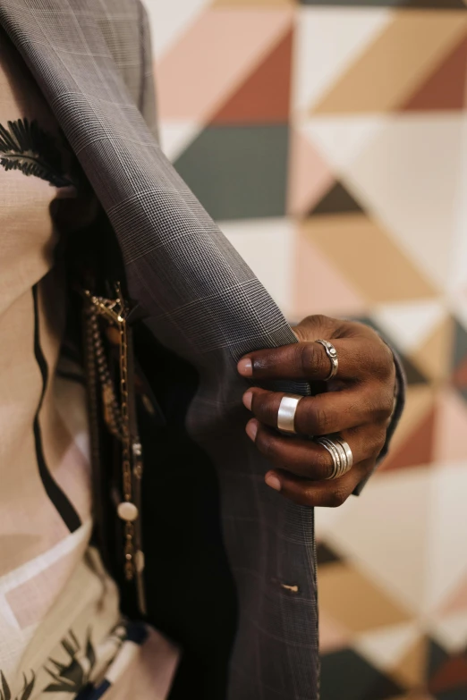 a woman in a suit and ring holding a purse