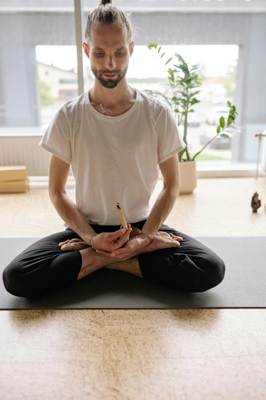 a man sits in a meditation pose while doing yoga