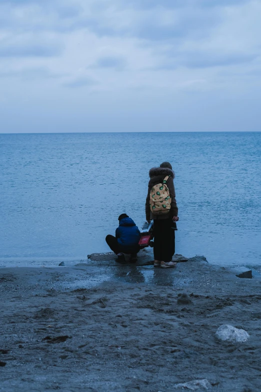 a child with a back pack is on the beach