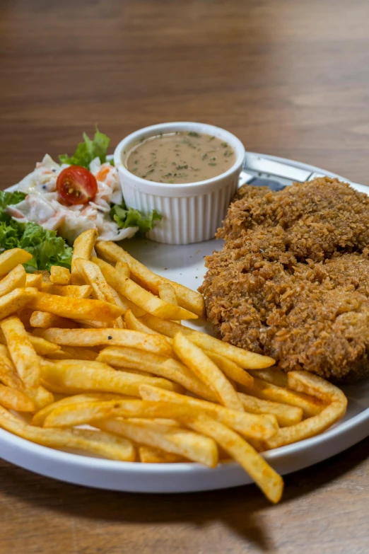 a white plate topped with fried chicken next to french fries