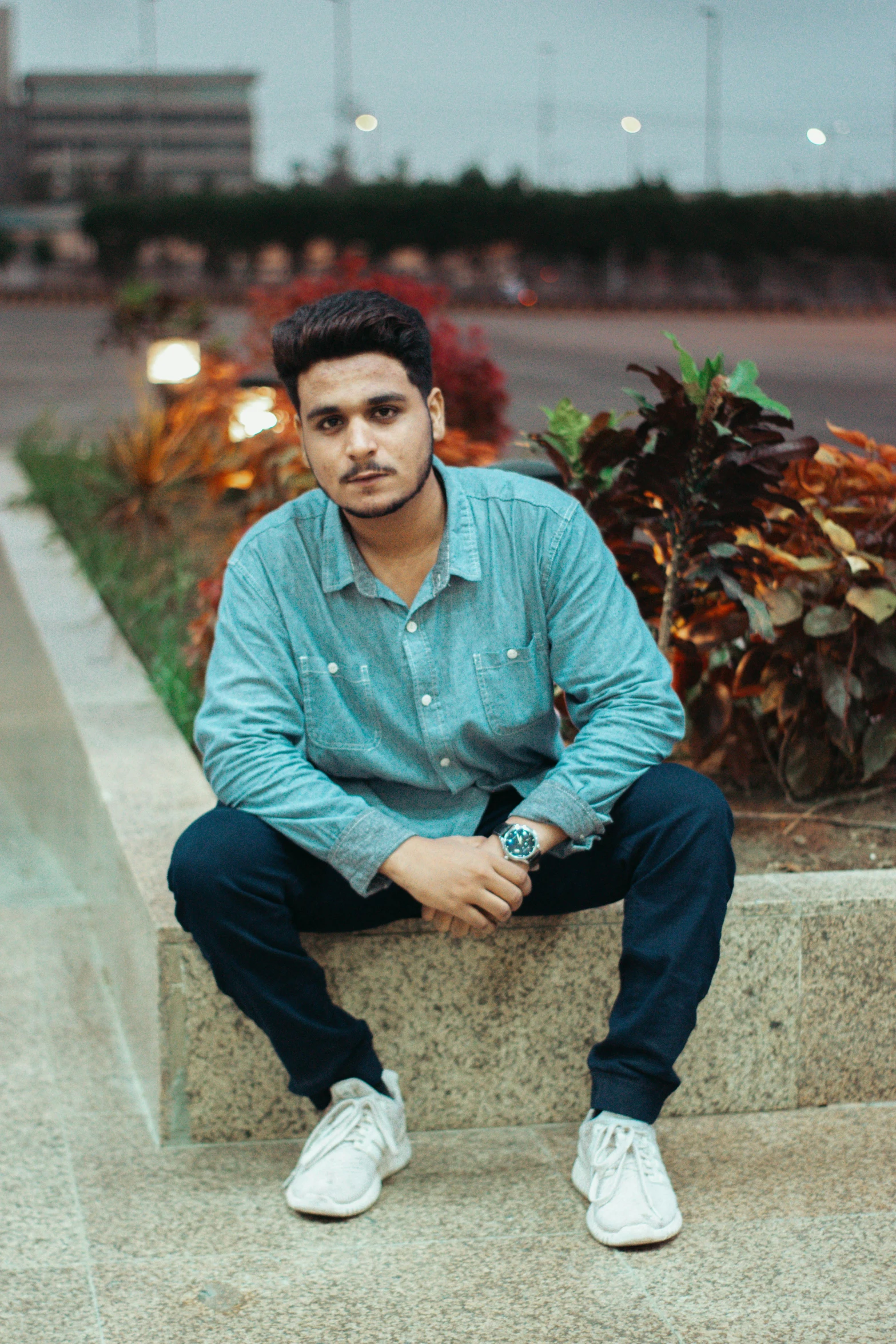 a man sits on steps with his legs crossed