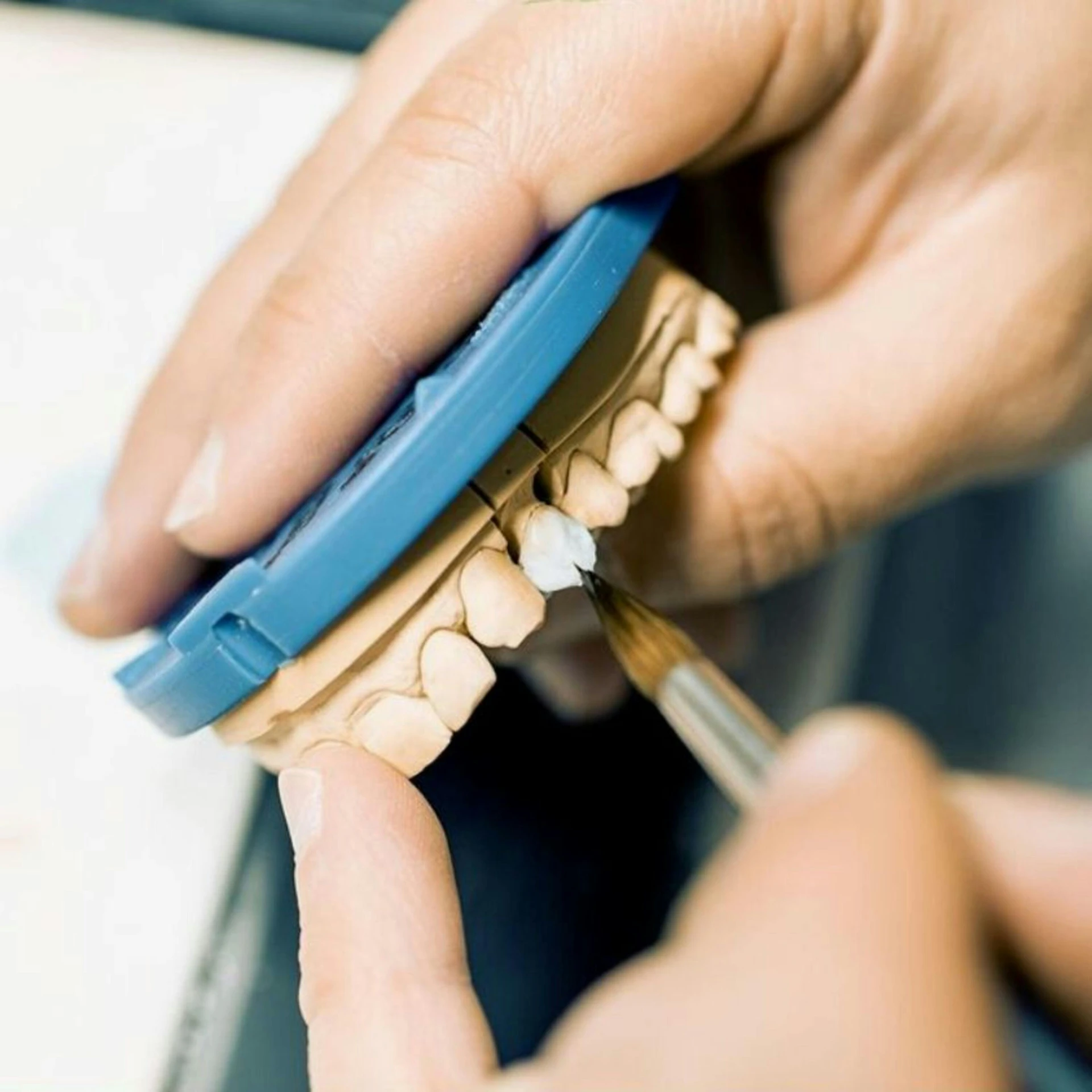 someone using a clip to cut the tooth with a toothbrush