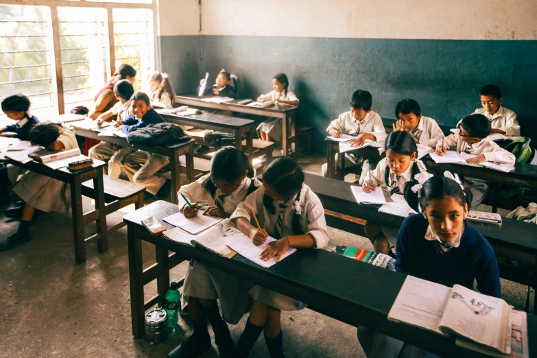 young children in their desks with papers and notebooks