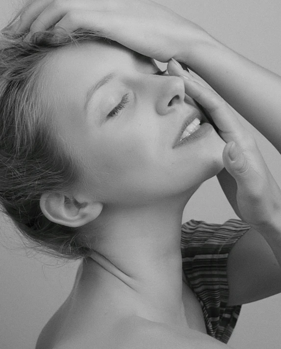 a woman with short hair putting her arm over her head