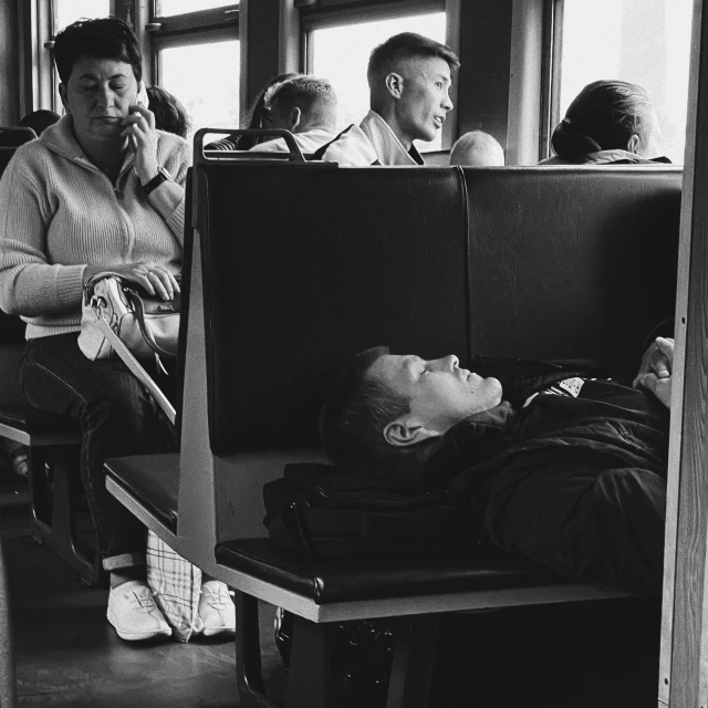 a black and white po shows people waiting on a bus