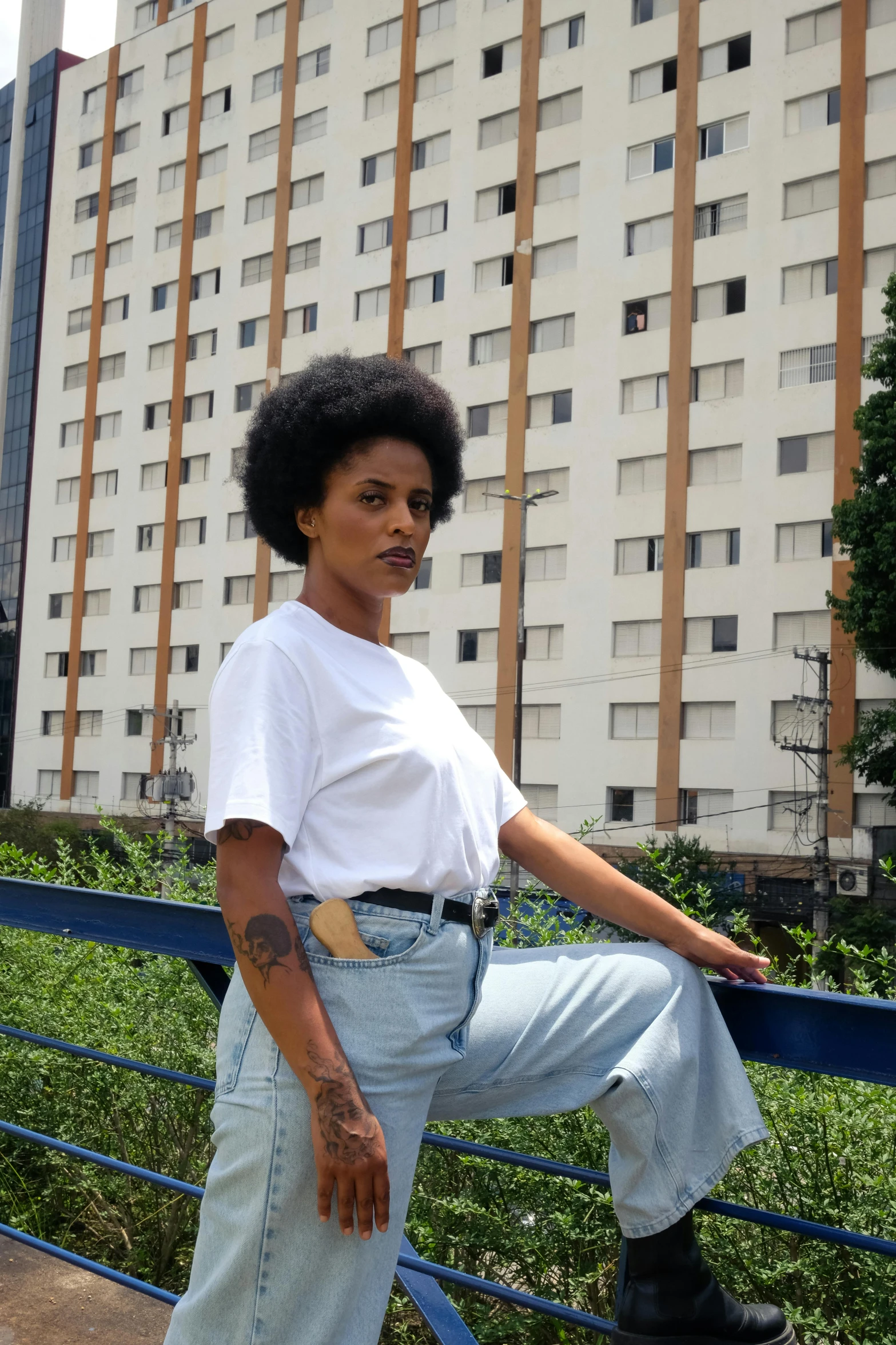 a person sitting on a rail with a building in the background