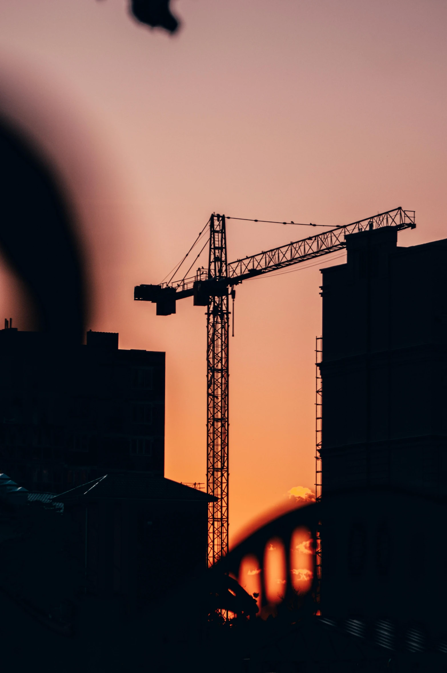 a crane that is standing in the air with a sunset background