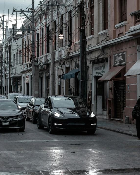 cars drive down an empty city street at dusk