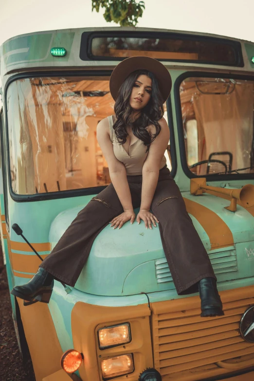 a woman in a hat is sitting on top of a truck