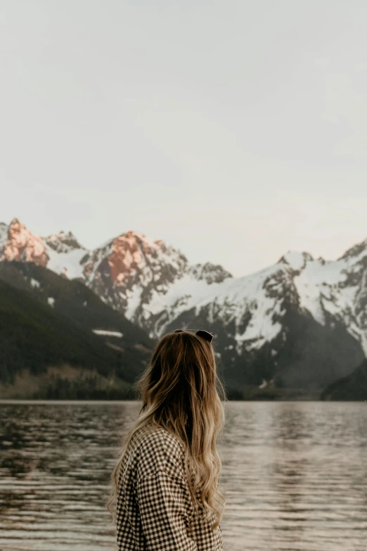 a person standing on top of a lake near a mountain