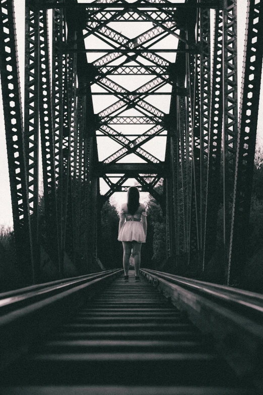 an old pograph with the person walking down the train tracks